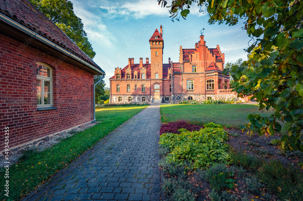 Obraz premium Spectacular evening view of old red brick Jaunmoku castle, Latvia, Europe. Stunning summer scene of Rigas countryside, Latvia, Europe. Traveling concept background.