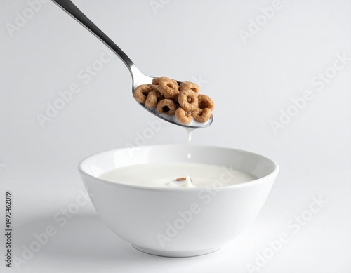 Cereal Spoonful over Bowl of Milk: A close-up shot captures a spoonful of cereal rings being held over a pristine white bowl, evoking a sense of anticipation and freshness.
