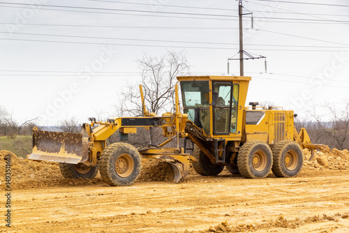 Motor grader on a construction site. Road construction.
