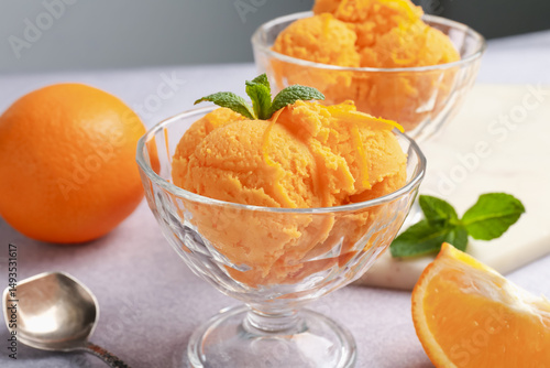 Fototapeta Naklejka Na Ścianę i Meble -  Tasty orange sorbet, fresh fruits and mint on light grey table, closeup