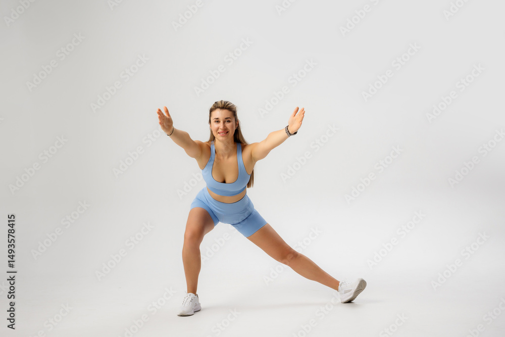 Fototapeta premium Fitness enthusiast performs a lateral lunge exercise in a modern studio setting during a workout session