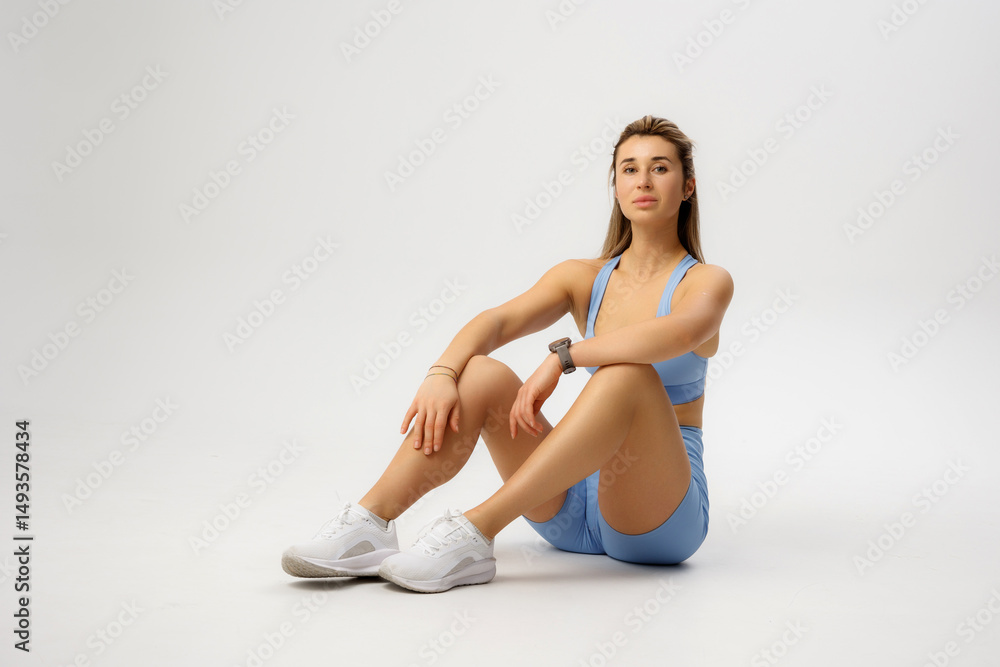Fototapeta premium Fitness model showcasing athletic wear in a minimalist studio setting during a professional photoshoot