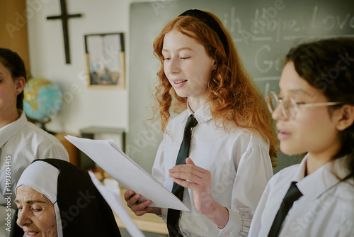 Bild auf Leinwand Group of students and nun engaged in academic presentation, with cross and black