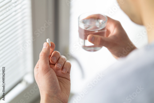 Close up of man's hands taking pill
