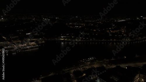 Drone flies from Episcopal Palace of Porto over the Douro River toward Gaia at night