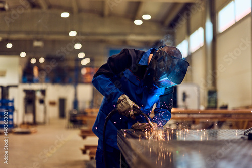 Fotografie Worker Performing Welding in Industrial Workshop with Spark Effects