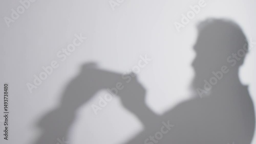 Wallpaper Mural Grayscale of a blurry shadow of a man playing a video game against a white background Torontodigital.ca