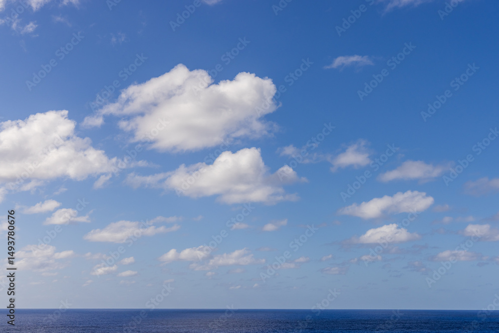 Obraz premium Bright Cloudscape Over the Pacific Ocean Under a Clear Blue Sky