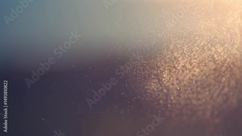 Abstract macro shot of golden glittering dust particles suspended in air with soft blue and golden light, providing a dreamy and ethereal background.
