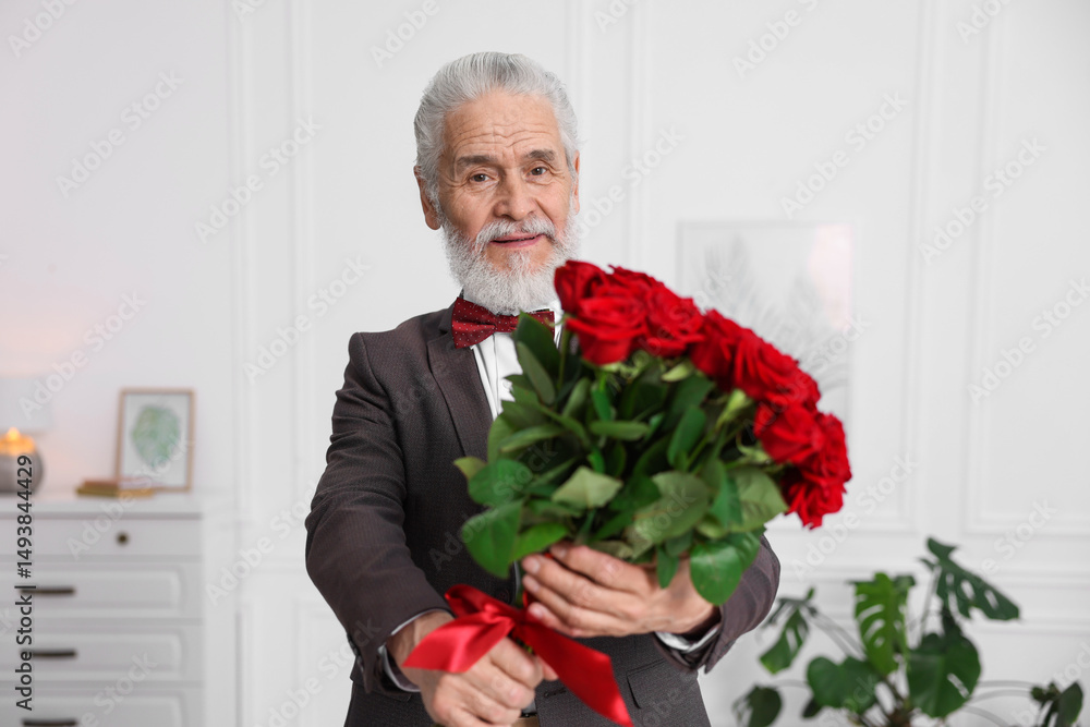 Senior man with bouquet of red roses at home Senior man with bouquet of red roses at home