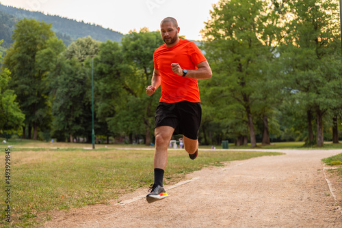 A sporty athletic man running in the park, active healthy lifestyle.