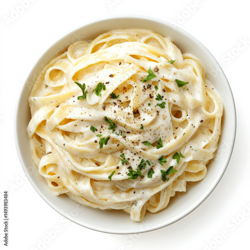 A bowl of creamy fettuccine Alfredo, with thick pasta coated in a velvety Parmesan cheese sauce, garnished with freshly cracked black pepper and chopped parsley. A rich Italian classic. Isolated on
