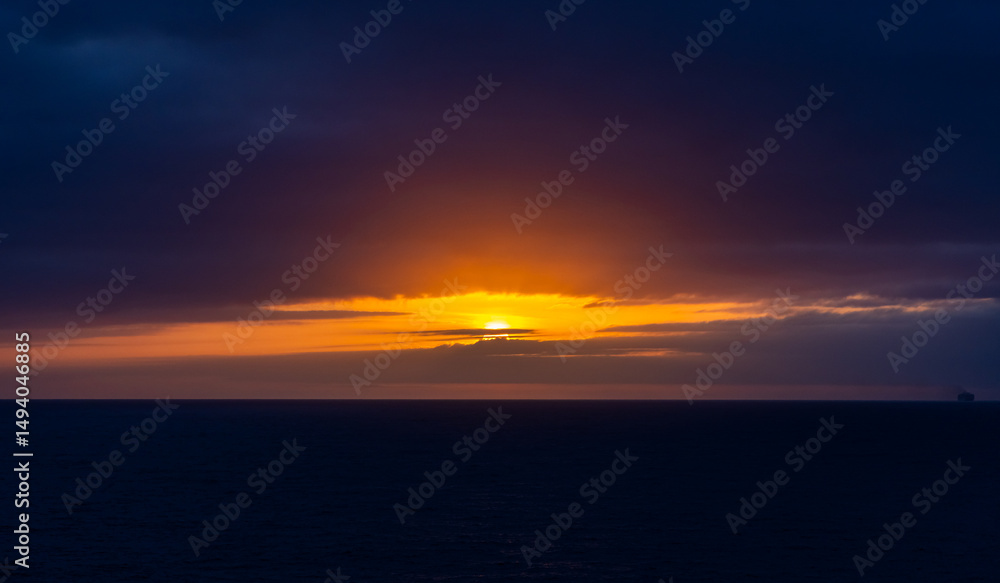 Obraz premium Vivid Sunset Over the Pacific Ocean with Dramatic Cloudscape