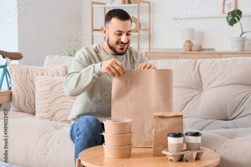 Young man with paper bag si...