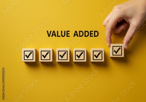Value Added Concept. A hand arranging wooden blocks with plus signs Value Added representing growth, improvement, and added value in business and projects. Positive thinking or personal