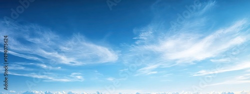 Clear blue sky with wispy white clouds over a distant horizon during daytime