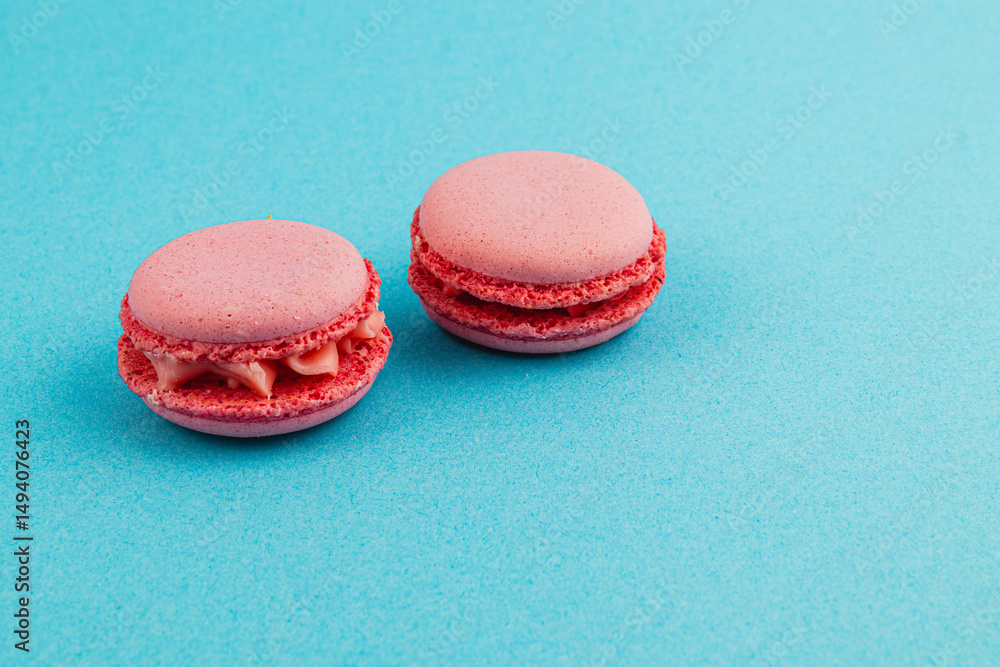 Obraz premium Raspberry macarons on a turquoise background