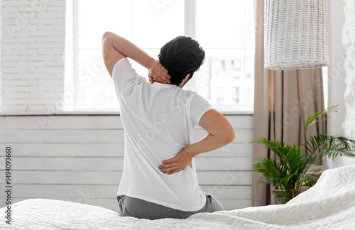Photography Unrecognizable guy suffering from back pain in bedroom, waking up in morning, si
