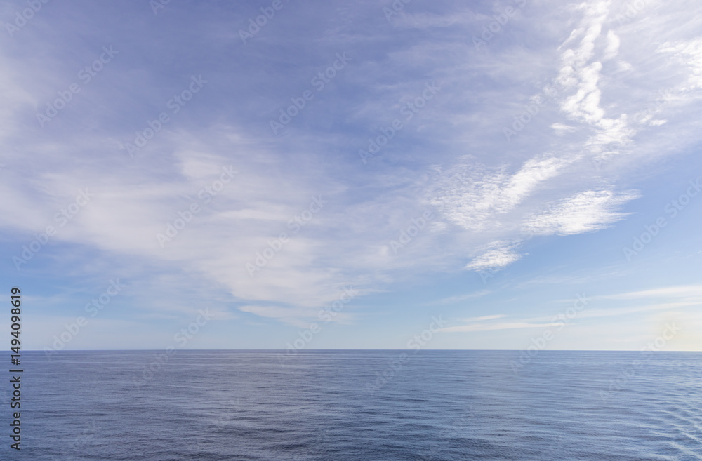 Obraz premium Serene Sky Reflected Over the Pacific Ocean Under a Light Cloudscape