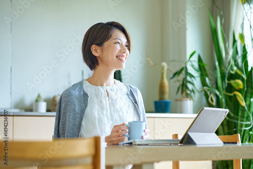仕事中にマグカップを持って休憩する女性