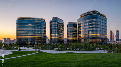 Modern buildings in Almaty, a large glass building with a round roof and three tall towers behind it, a city square park near the office complex