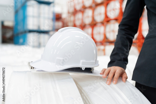 Close-up of hard hat image of European engineer working with operations team to improve plastics yield and drive sustainable business growth.