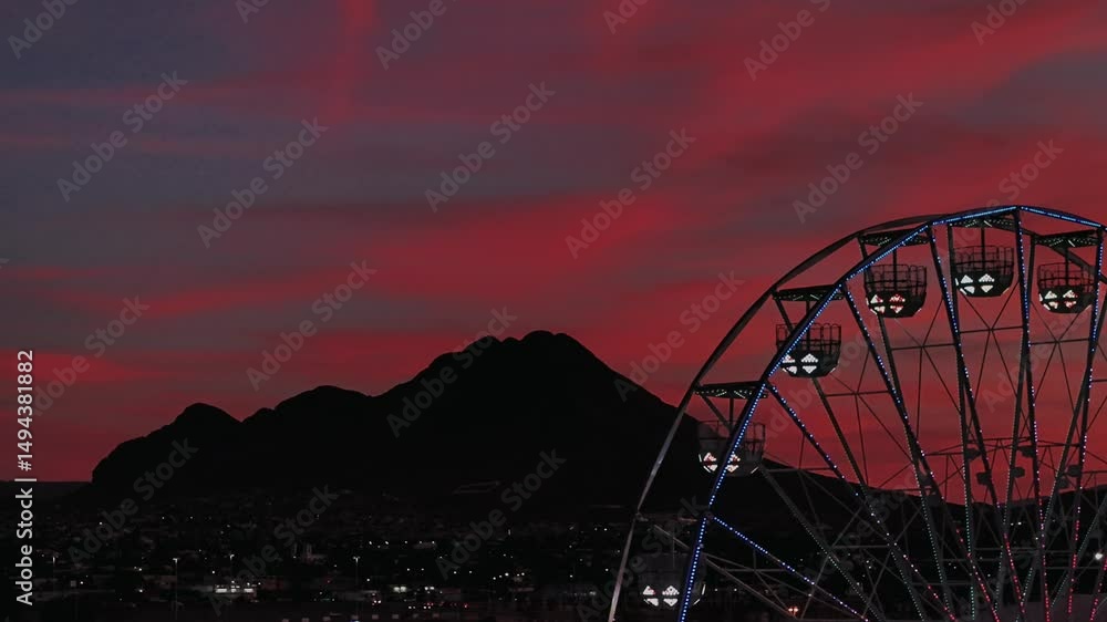Noria en la feria de santa rita en ciudad Chihuahua en el atardecer, noria y juegos mecanicos en parque de diversiones