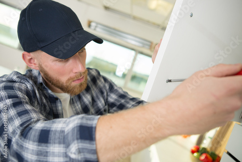 Tableau sur toile man installing a cabinet