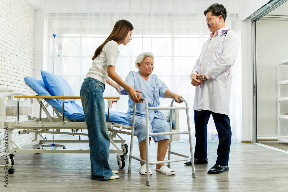 Fototapeta premium Senior woman using a walker with help from a caregiver and support from a doctor in a clinic. Represents rehabilitation, elderly care, mobility support, and recovery in a medical setting.
