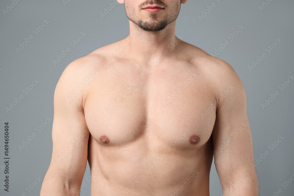 Fototapeta premium Young man with smooth chest after epilation procedure on light grey background, closeup
