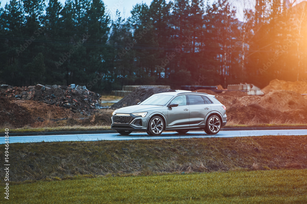 Modern SUV driving along rural road with green scenery Modern SUV driving along rural road with green scenery