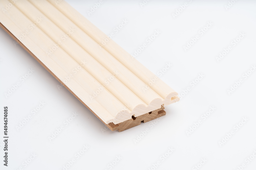 Profiled light wood molding piece with decorative ridges and tongue-and-groove joints, shown on a white background for product display.. Profiled light wood molding piece with decorative ridges and tongue-and-groove joints, shown on a white background for product display..