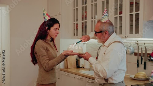 Grandfather lights candles on a cake held by his daughter