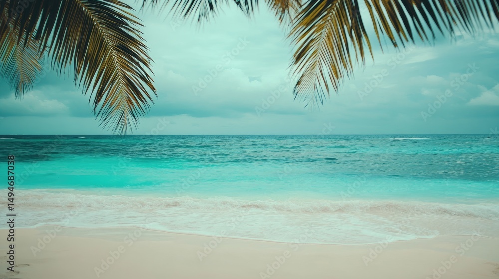 Naklejka premium Tropical beach scene framed by palm leaves under a cloudy sky.