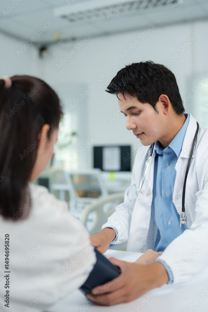 Doctor checking blood pressure of patient in medical clinic Doctor checking blood pressure of patient in medical clinic