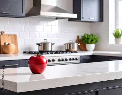 Fresh fruits placed on a kitchen counter alongside a glass of juice, set against a modern dark-toned kitchen background — a clean and natural food scene with moody lighting.