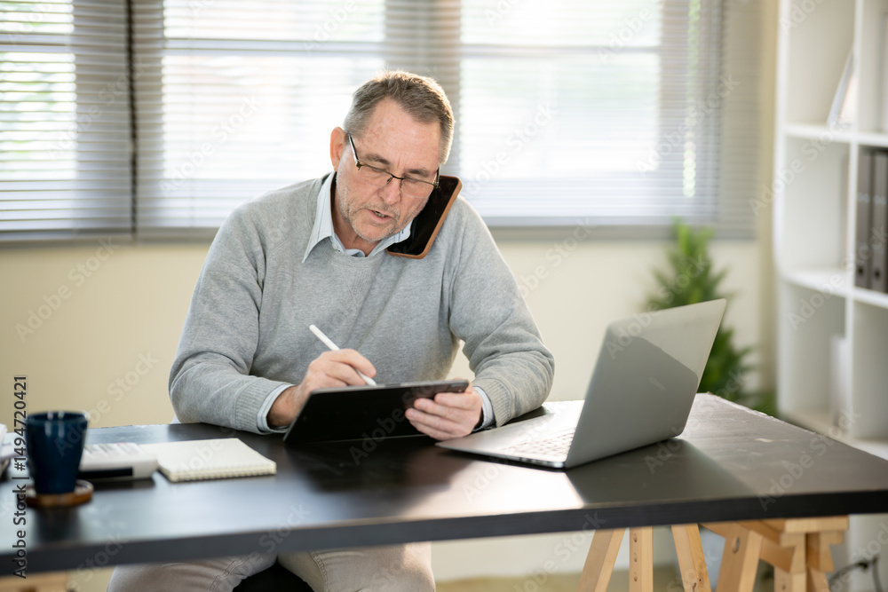 A businessman is sitting at his desk working. A businessman is sitting at his desk working.