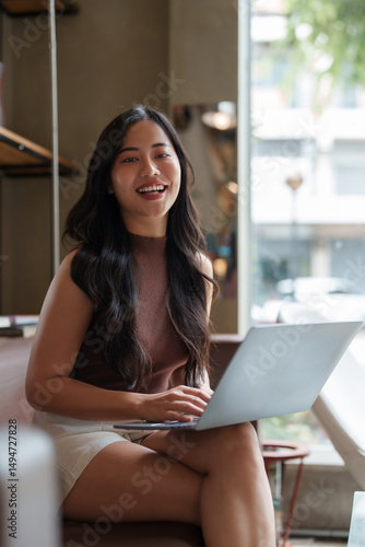 Free Download Smiling freelancer working on laptop in coworking space - GFXLoad