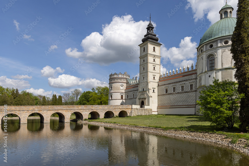 Fototapeta premium View of 17th century Krasiczyn Castle and arcaded bridge over pond in castle park, Krasiczyn, Poland