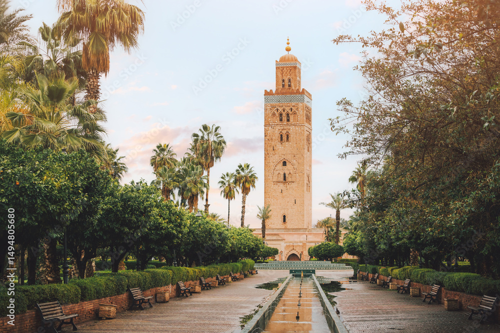 The majestic Koutoubia Mosque stands tall amidst a tranquil oasis of palm trees and gardens in Marrakech, Morocco, creating a serene scene The majestic Koutoubia Mosque stands tall amidst a tranquil oasis of palm trees and gardens in Marrakech, Morocco, creating a serene scene