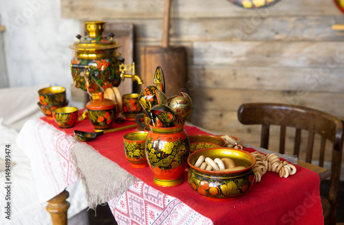 Foto Traditional Khokhloma folk craft table setting with samovar, spoons, and snacks