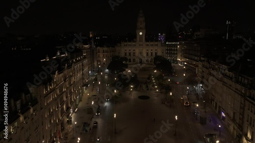 Drone flies over Aliados Square toward the city hall at night in Porto, Portugal