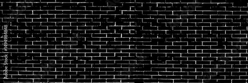 A black and white grungy brick wall. Dilapidated brick pattern in black and white. Dark brick wall background. 