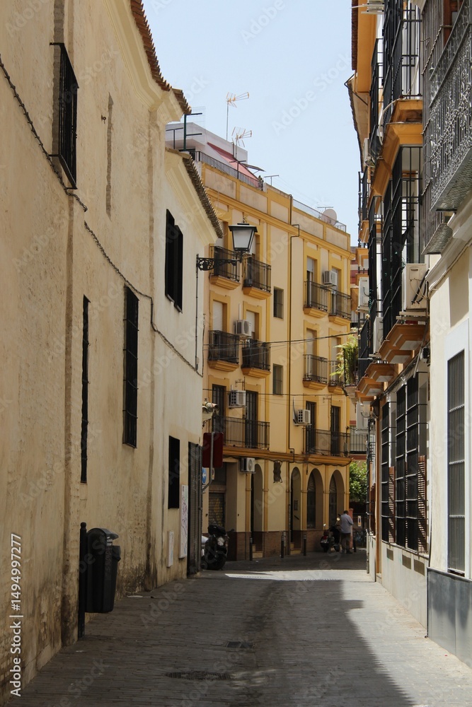 Fototapeta premium Charming Seville Street Scene – Historic Architecture and Local Life