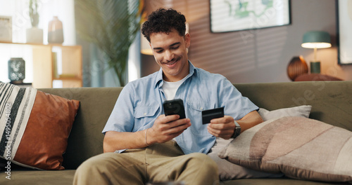 Home, online shopping and man with smartphone, card and payment for digital product, sale and browsing. House, customer and person with credit for ecommerce, living room and scroll for purchase