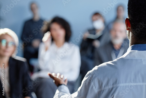 Bild auf Leinwand Rear view of African American male physician presenting at meeting with colleagu