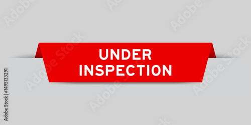 Red color inserted label with word under inspection on gray background