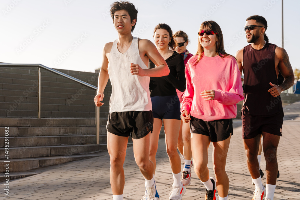 Naklejka premium Group of six athletes running and laughing while talking, outdoors