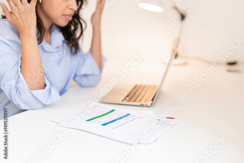 Tableau sur toile Young woman feels stressed while working on a laptop at home with documents scat