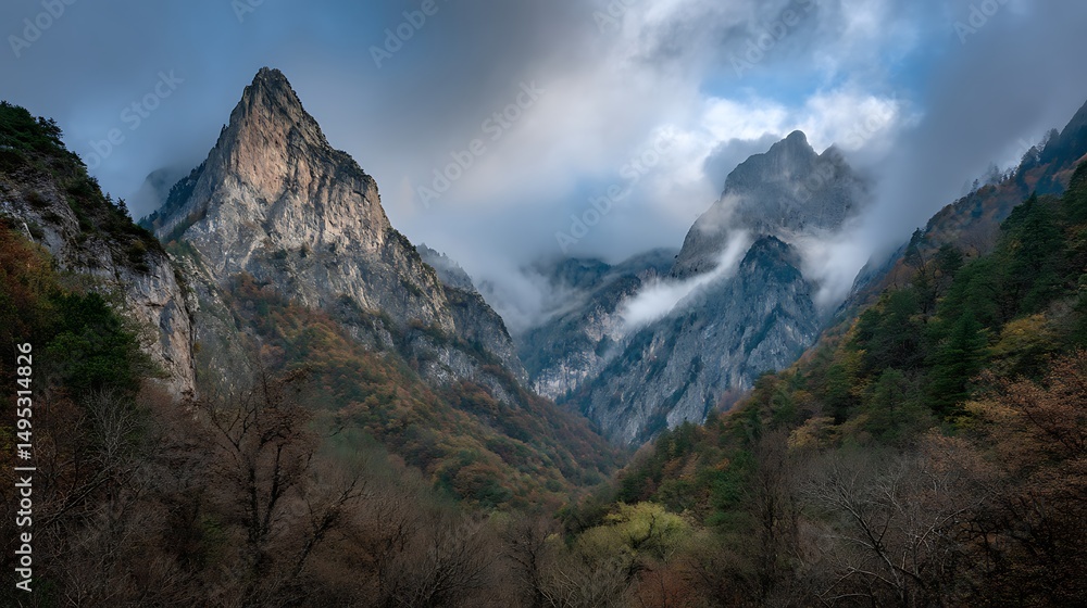 Naklejka premium Majestic Mountain Range Surrounded by Clouds and Lush Forests